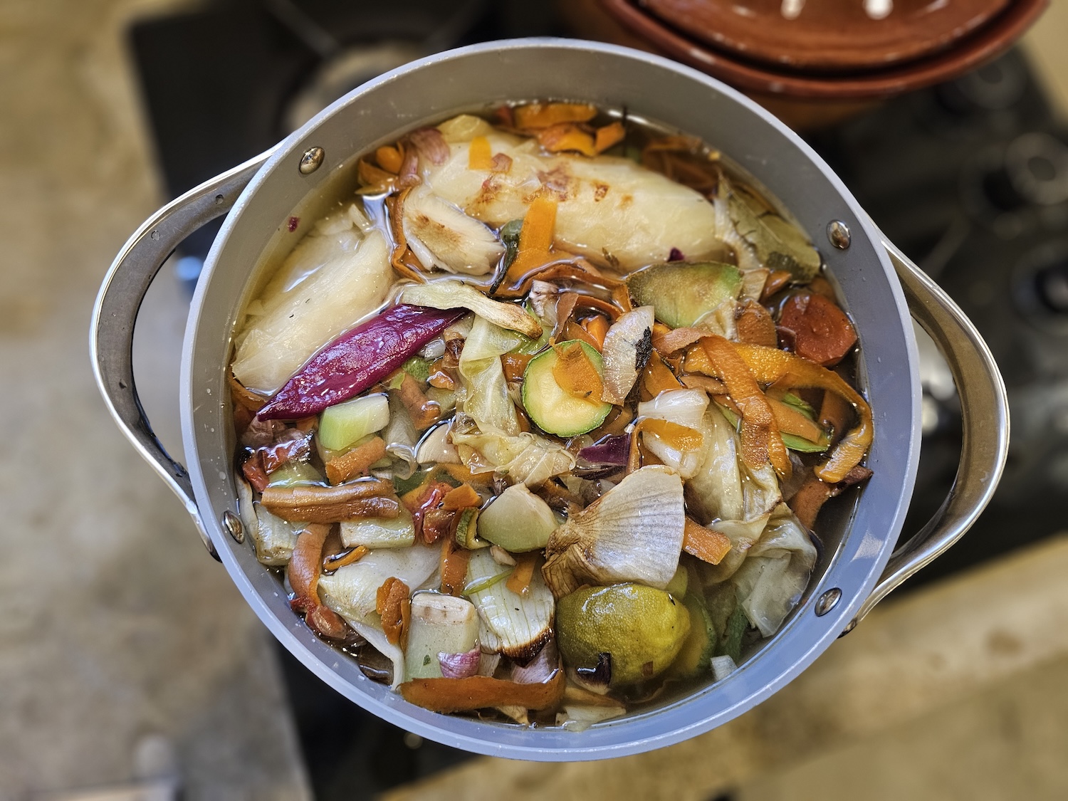 roasted vegetables in a pot with water - how to make vegetable broth from vegetable scraps